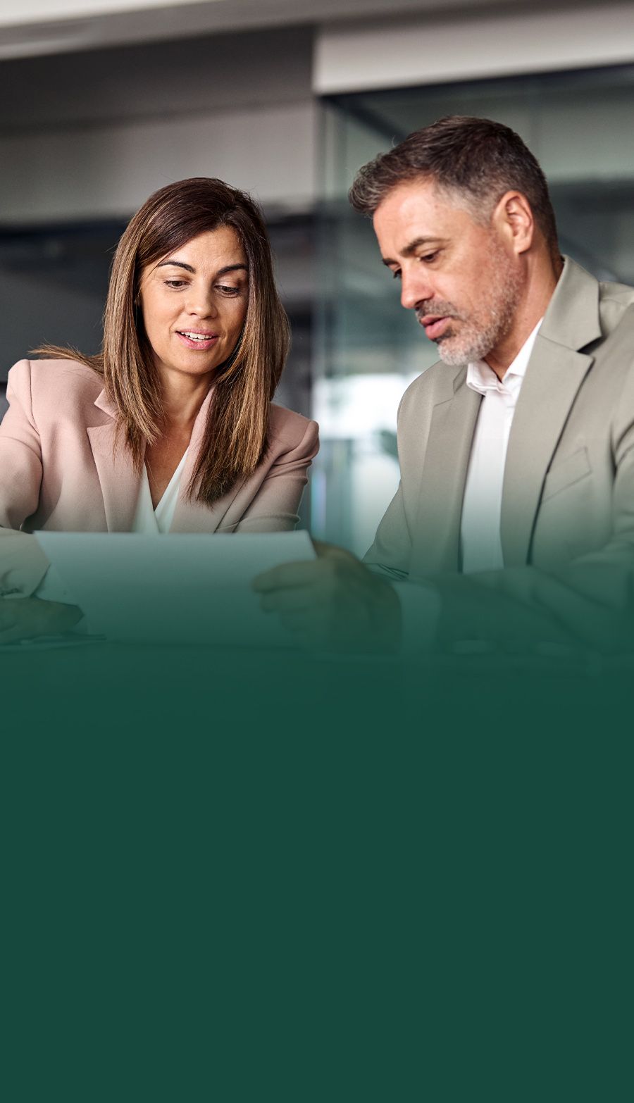 Business professionals reviewing documents together in a modern office setting.