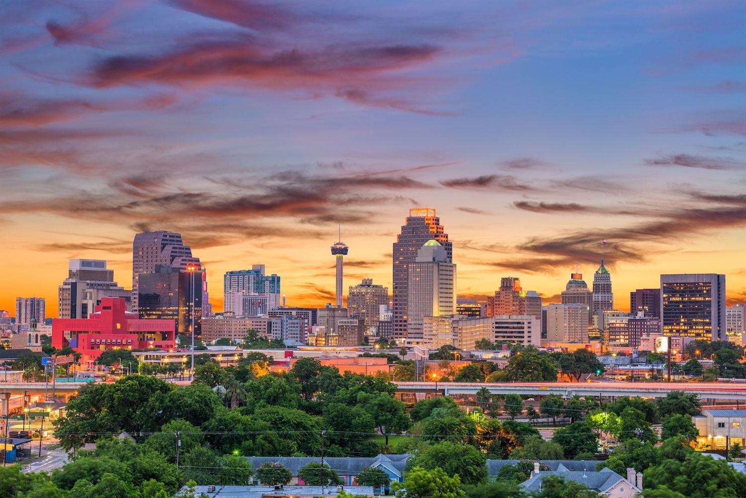 San Antonio skyline at sunset with vibrant sky and skyscrapers, showcasing city architecture and natural beauty.