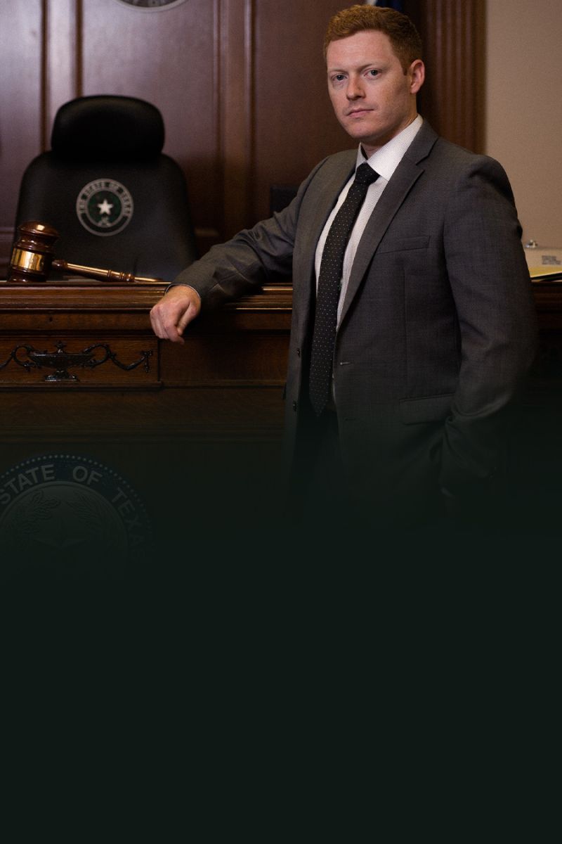 Man in a suit stands confidently in a Texas courtroom with a gavel, symbolizing justice and authority.
