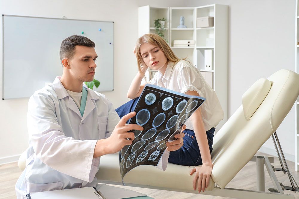 Doctor showing brain scan results to a concerned patient in a modern medical office.