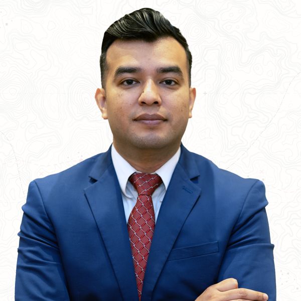 Man in blue suit and red tie with arms crossed against a white background.