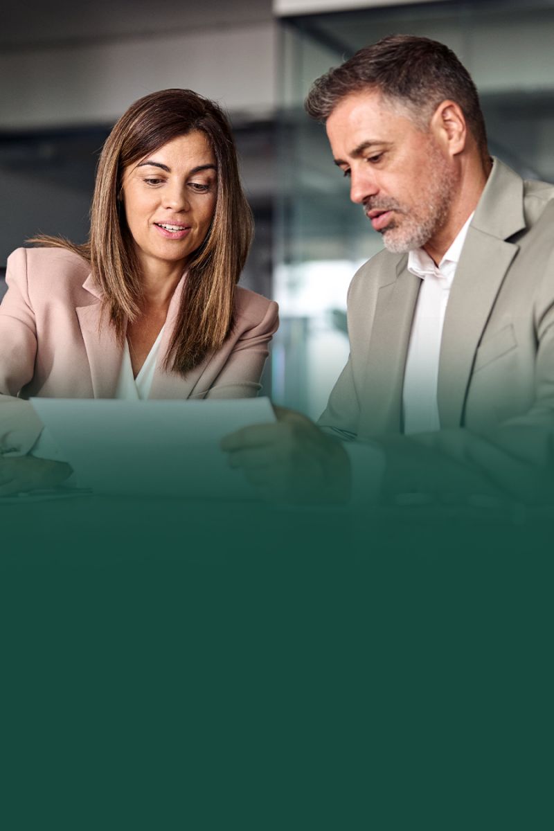 Business professionals reviewing documents together in a modern office setting.