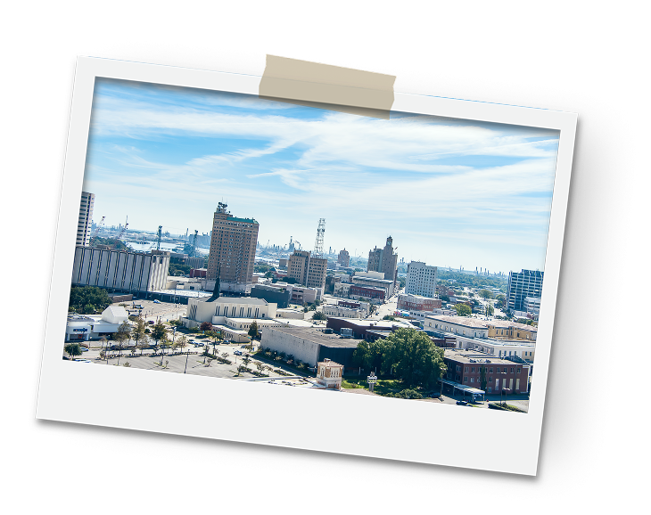 Aerial view of a city skyline with tall buildings on a sunny day. Urban landscape and clear blue sky.
