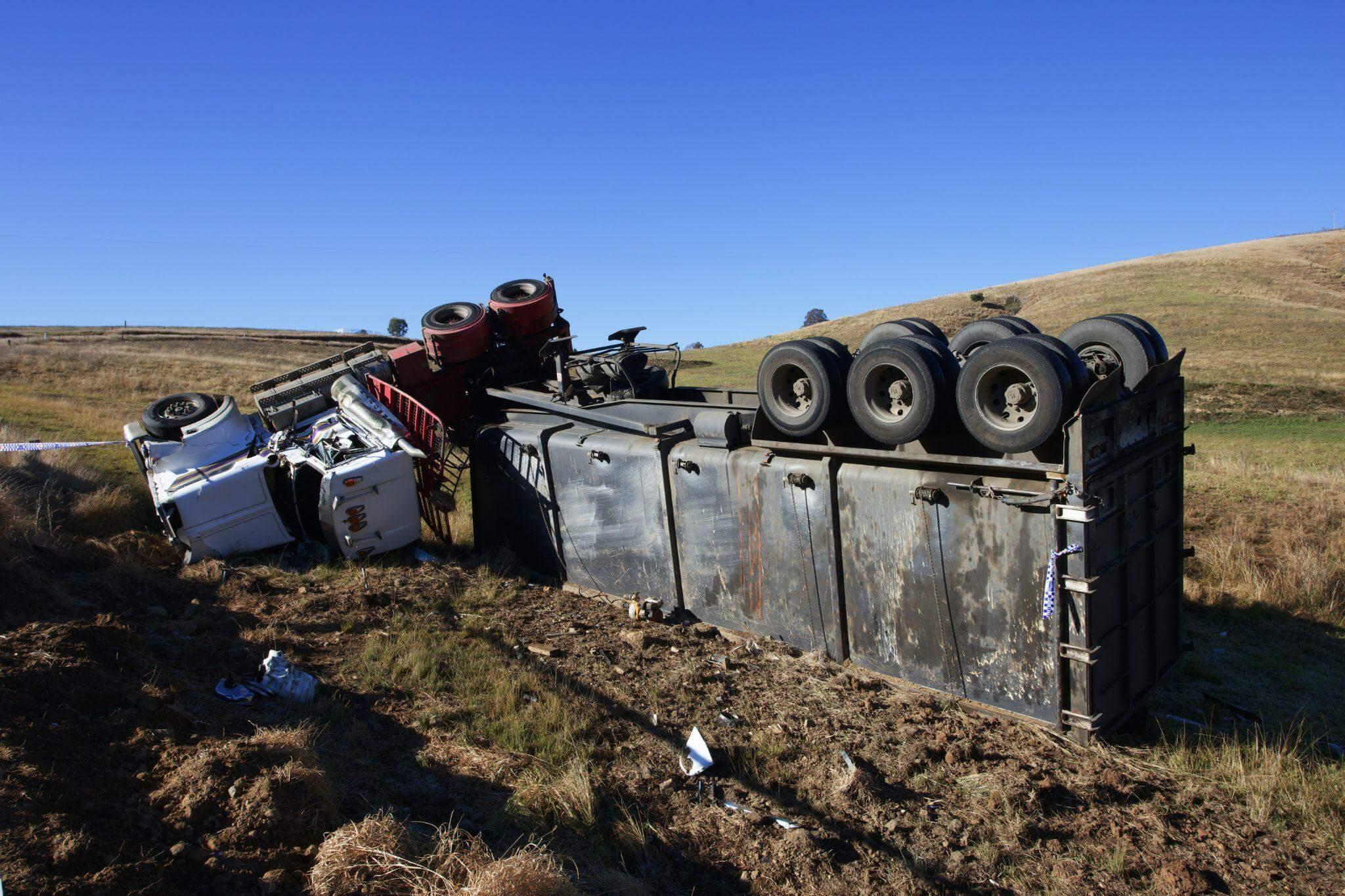 a truck that has flipped over on the side of the highway